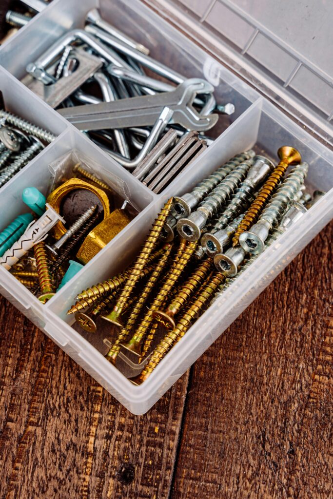 pexels-photo-5853930-5853930 Close-up view of a toolbox containing assorted screws, wrenches, and tools on a wooden surface.